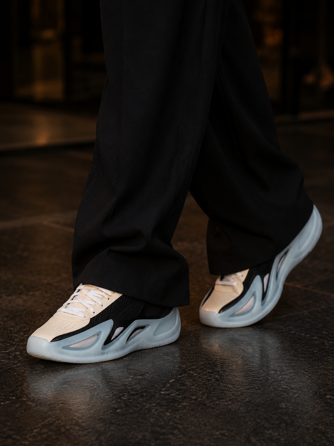 Walking in sneakers with wide tailored black trousers